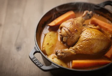 Mafé de poulet fumant dans cocotte rustique
