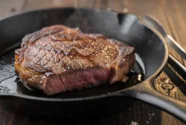 Steak ribeye parfaitement saisi dans poêle en fonte